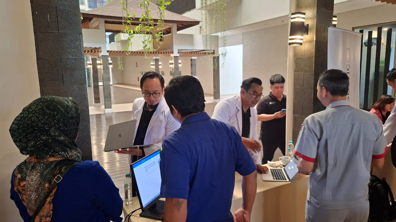 Tim Xecura menyiapkan booth konsultasi Cybersecurity Clinic di lobby hotel